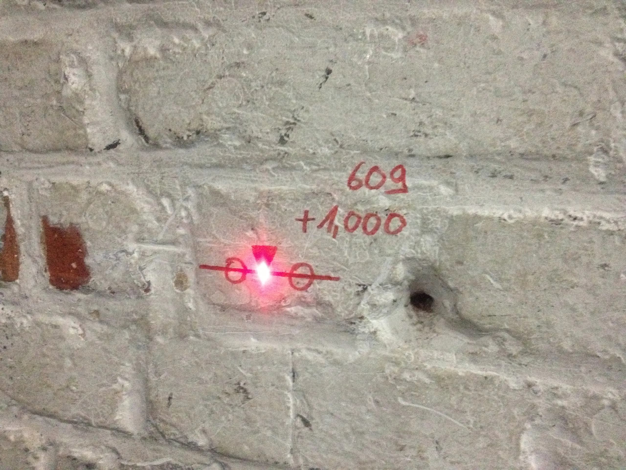 Mit Laser angezielter Höhenfestpunkt, beschriftet mit Station und Höhe