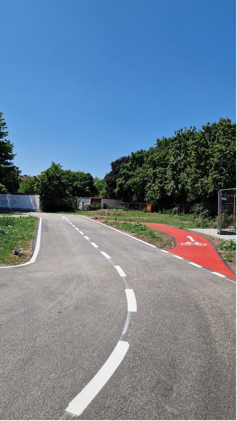 Frisch asphaltierte Übungsstrecke der Jugendverkehrsschule mit Mittelmarkierung und rotem Radweg